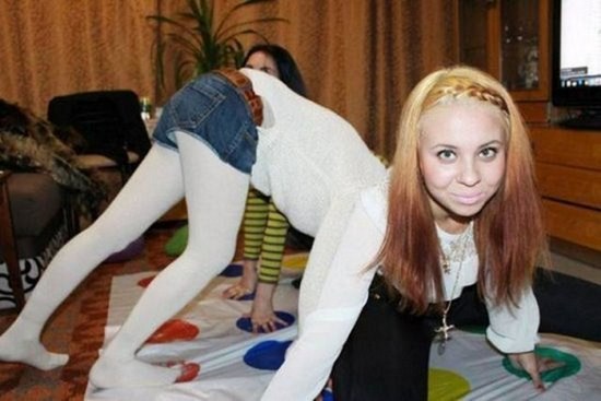 Girl bending over with another girl in the foreground that is an optical illusion on the prespective