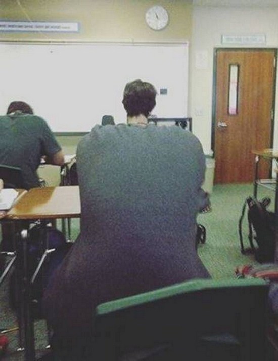 Optical illusion of huge body with tiny head in the classroom
