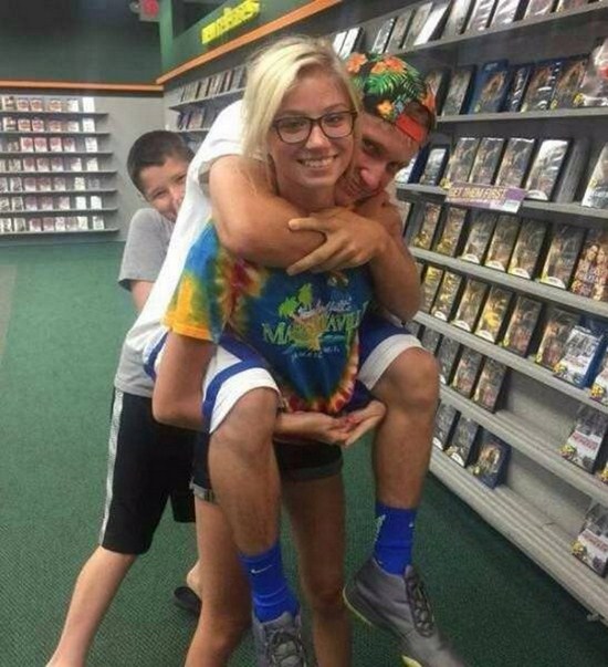Optical illusion couple posing in video store