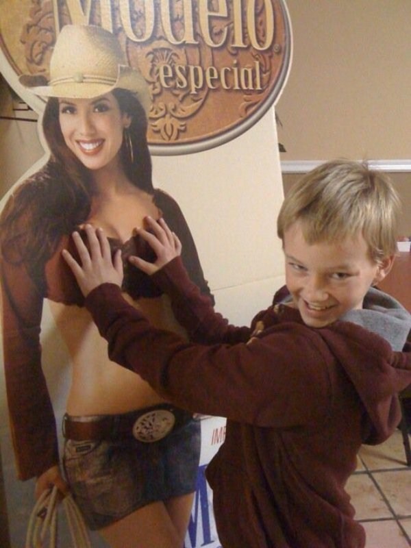 Kid groping a cardboard cutout of a girl