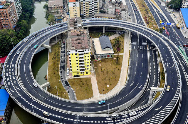 In Guangzhou, The Authorities Have Had To Build A Ring Road Around This Block Of Flats Because Three Families Would Not Budge