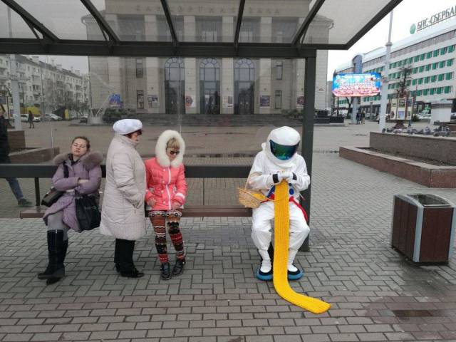 astronaut knitting in a bus stop