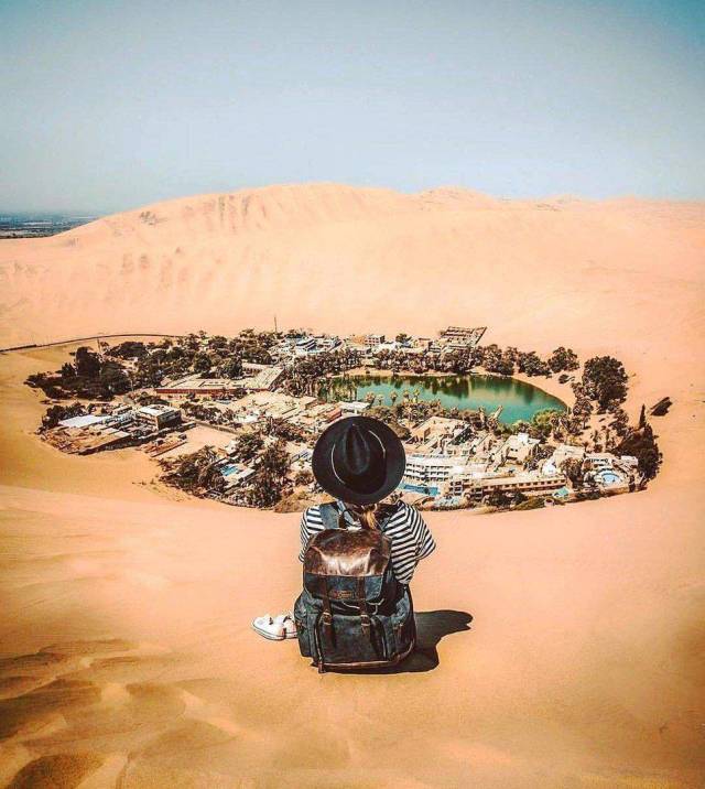 This beautiful place is a village in southwestern Peru called Huacachina. It's built around a small oasis surrounded by sand dunes.