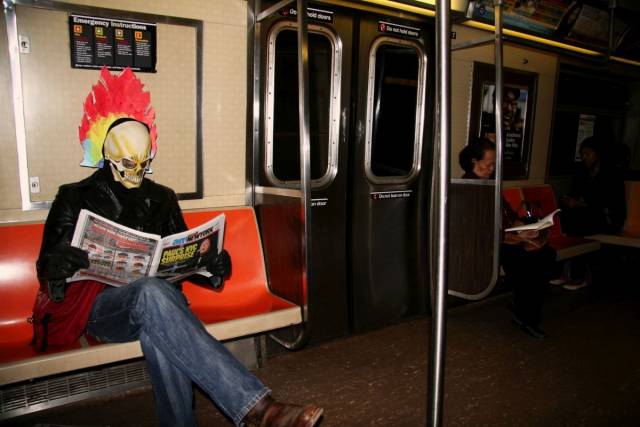 guy on a train wearing a creepy mask