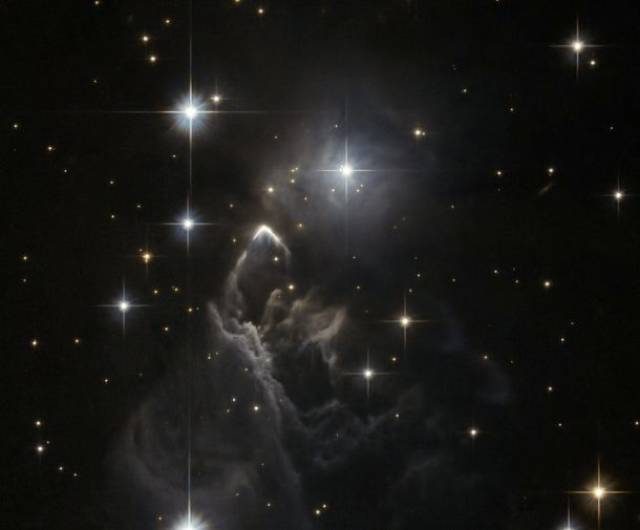 The Enigmatic Cloud-Its technical name being Nebula IRAS 05437+2502, little is known about this obscure nebula near the central plane of our galaxy. First discovered by the Infrared Astronomical Satellite (IRAS) in 1983, it was recently spotted again by the Hubble.