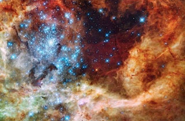 Stellar Cluster R136-This colorful image shows an extremely volatile region of the Large Magellanic Cloud near our galaxy, the Milky Way. The red gasses you see are hydrogen, the green are oxygen, and the blue “diamonds” are actually some of the largest known stars in the universe with several being hundreds of times bigger than the Sun.