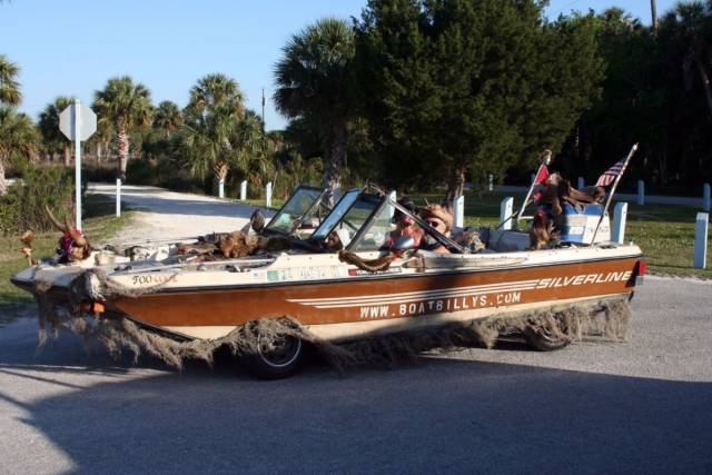 boat that looks like a car with wheels that is driving on the road