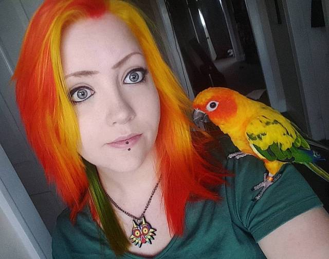 woman with pet bird that have the same color motif