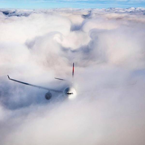 delta airplane breaking through clouds