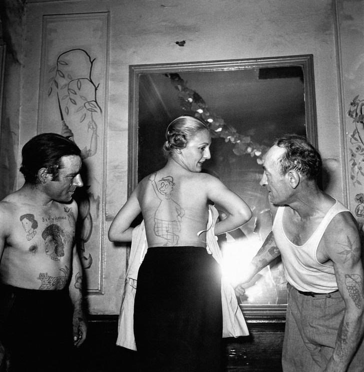 People demonstrate the tattoos given to them during an amateur tattoo artist contest in France in 1950.