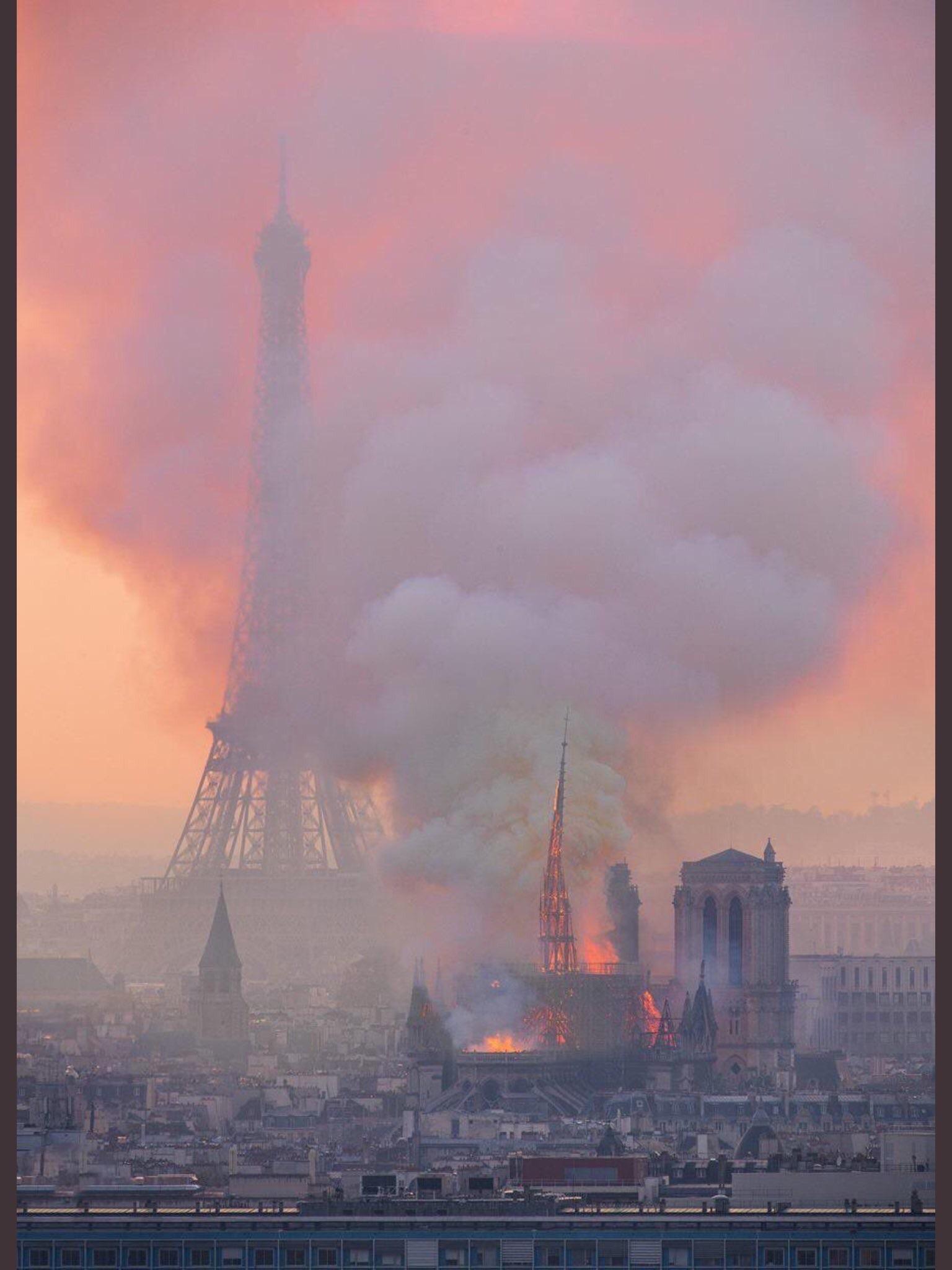 notre dame burning with eiffel tower in background