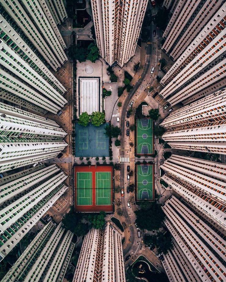 a top down view of a playground and basketball court surrounded by tall buildings