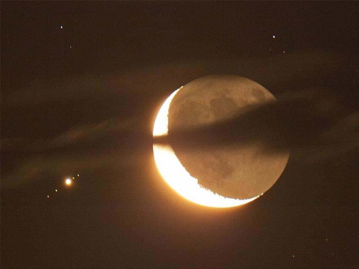 A crescent moon and Jupiter with 4 of its moons