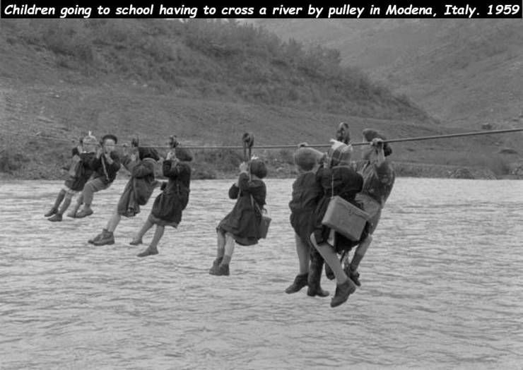 Children going to school having to cross a river by pulley in Modena, Italy. 1959