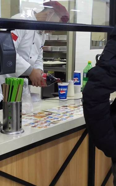 chinese knockoff pouring coca-cola into a pepsi cup