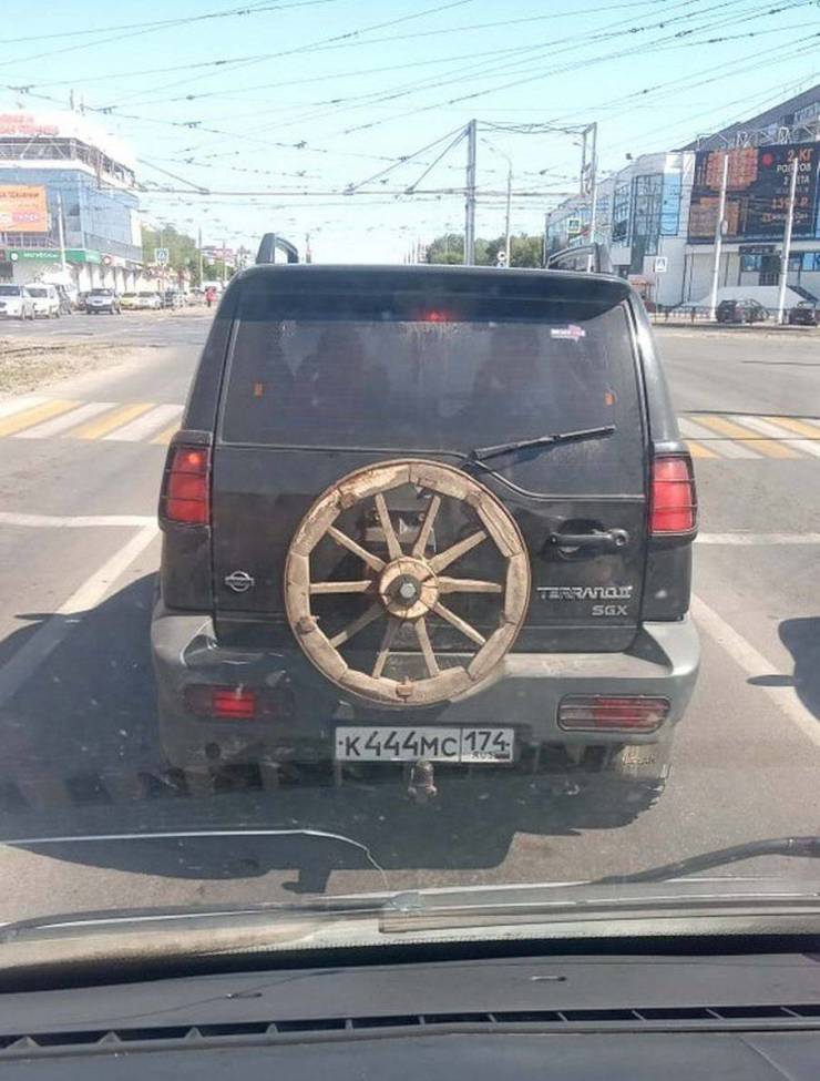 wooden wheel on the back of a modern car suv