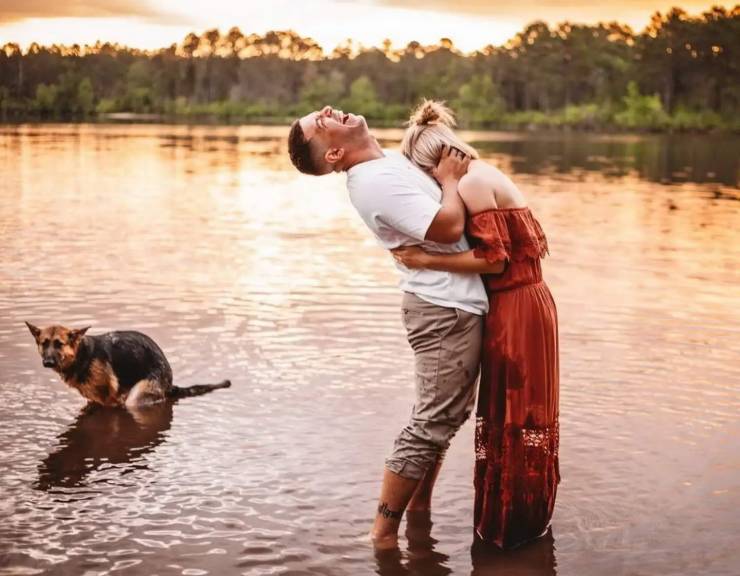 couple romantic photoshoot with dog pooping in the background