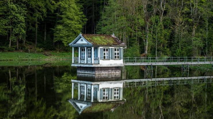 reflection of tiny house in middle of pond