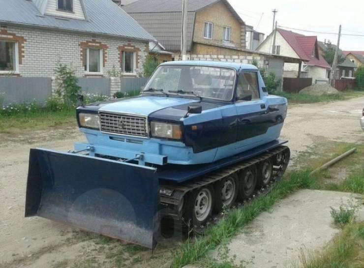 bulldozer tank with tiny blue car on top