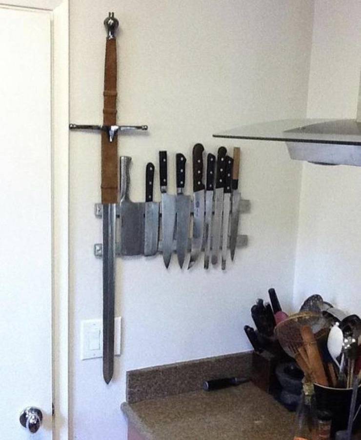 huge sword hung up on wall next to kitchen knives