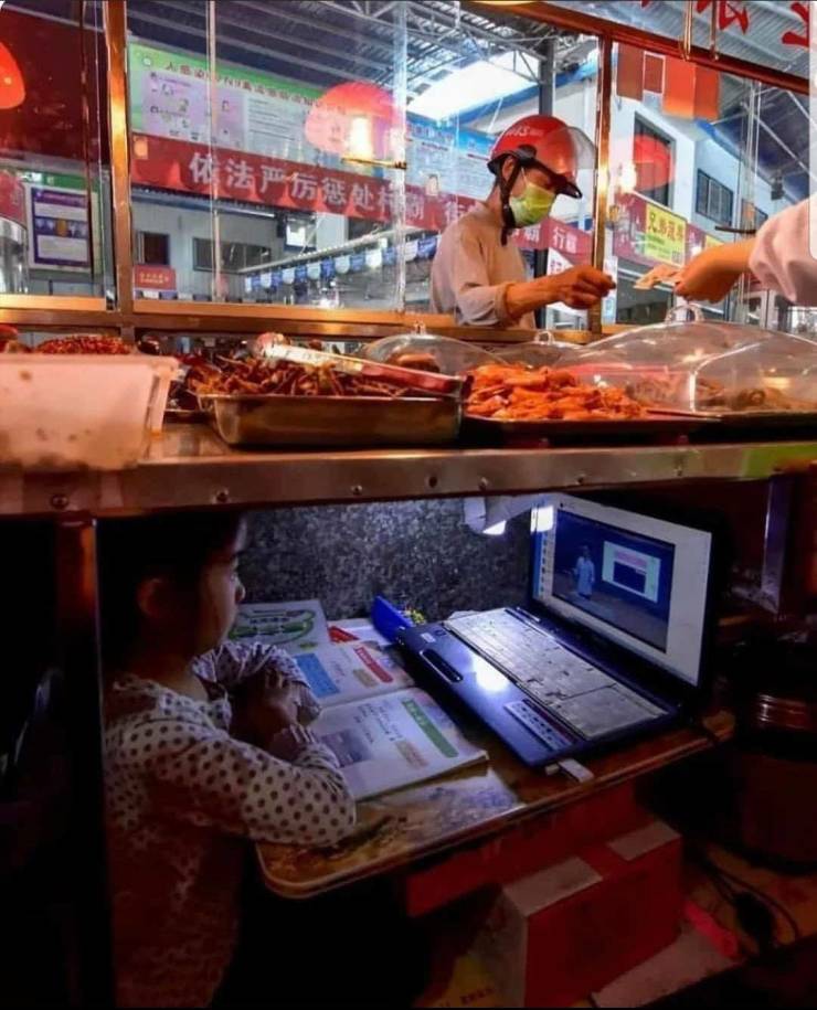 kid taking online class under her parents street food stand