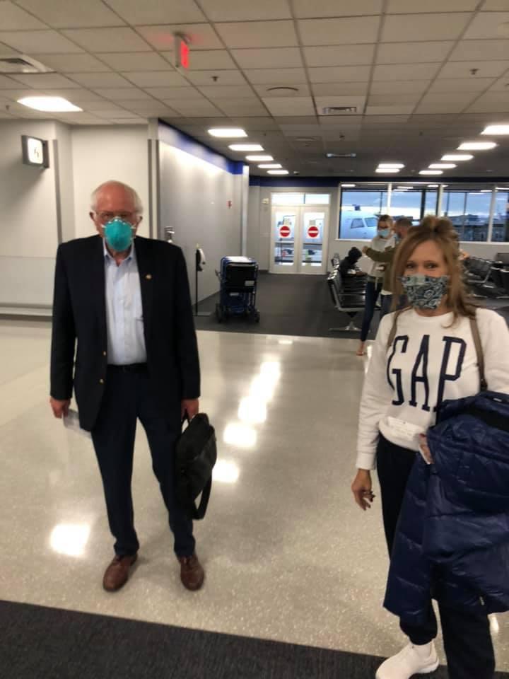 funny meme - bernie sanders in the airport wearing a mask