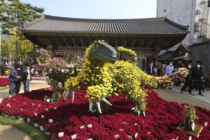 funny pics - dinosaur statue covered in flowers