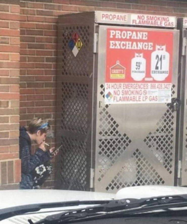 funny pics - employee smoking a cigarette nex to propane tanks Propane No Smoking Flammable Gas Propane