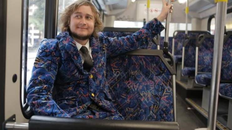 funny pictures - guy sitting on the bus wearing a suit made from the same fabric as the bus seats
