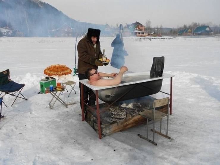 funny pictures - man taking hot bath outside in the frozen tundra