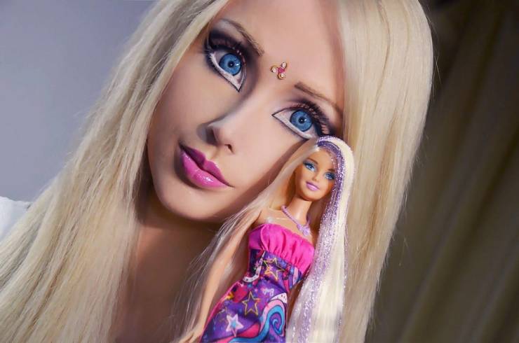 cool pics - woman who looks like a barbie holding a barbie doll