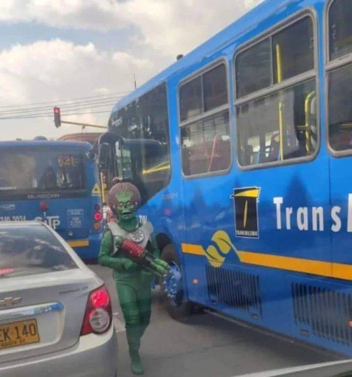 cool pics - guy dressed like green alien from movie mars attacks walking through traffic