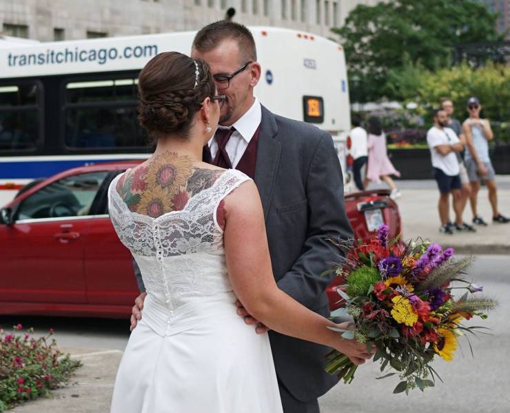 cool funny pics - wedding couple woman holding bouquet of flowers with flower tattoos on her back