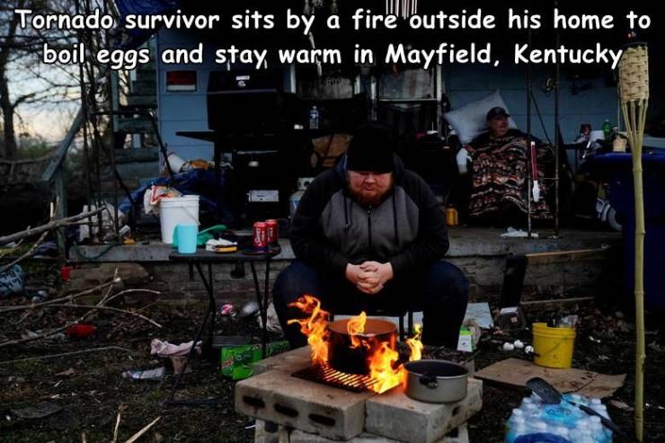 fun randoms - Tornado survivor sits by a fire outside his home to boil eggs and stay warm in Mayfield, Kentucky