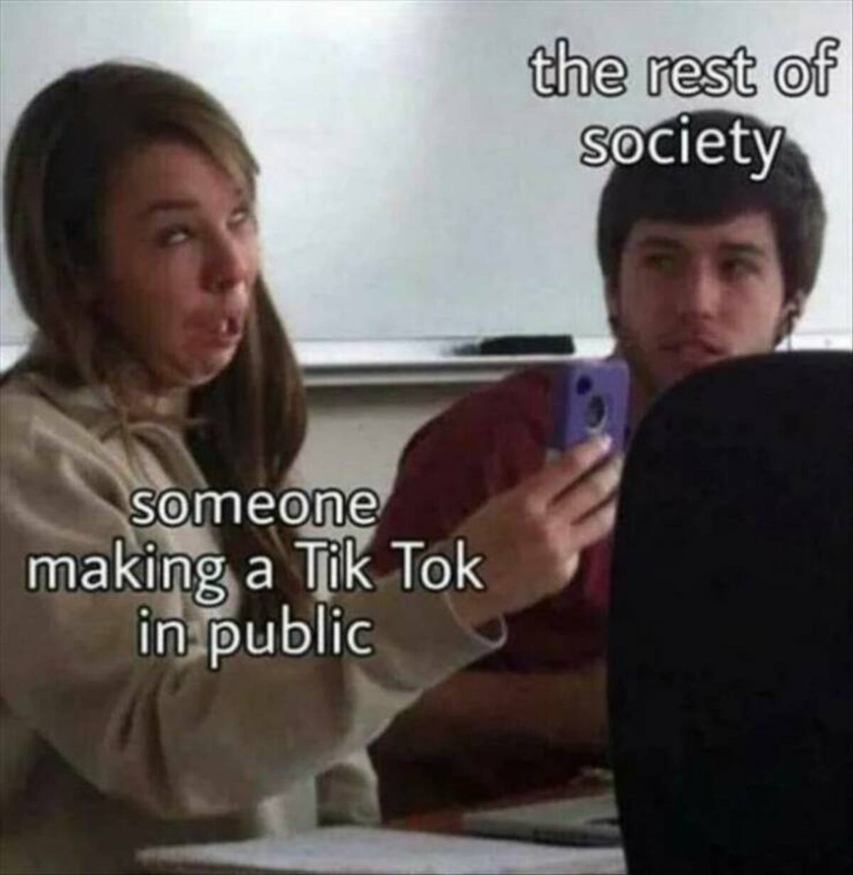 photo caption - someone making a Tik Tok in public the rest of Society