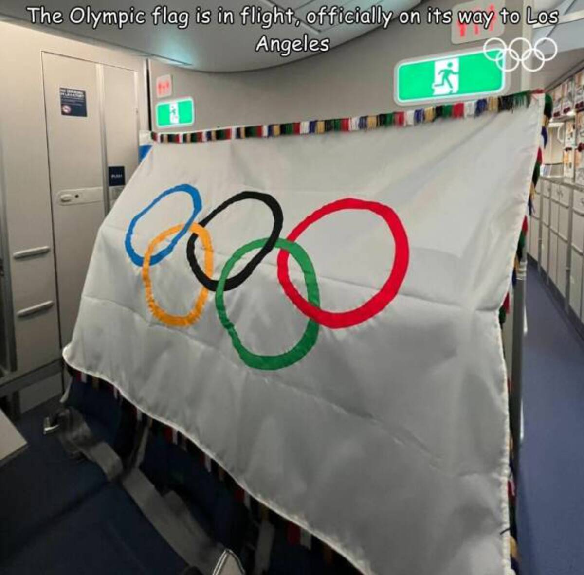 Olympic flag - The Olympic flag is in flight, officially on its way to Los Angeles Pu