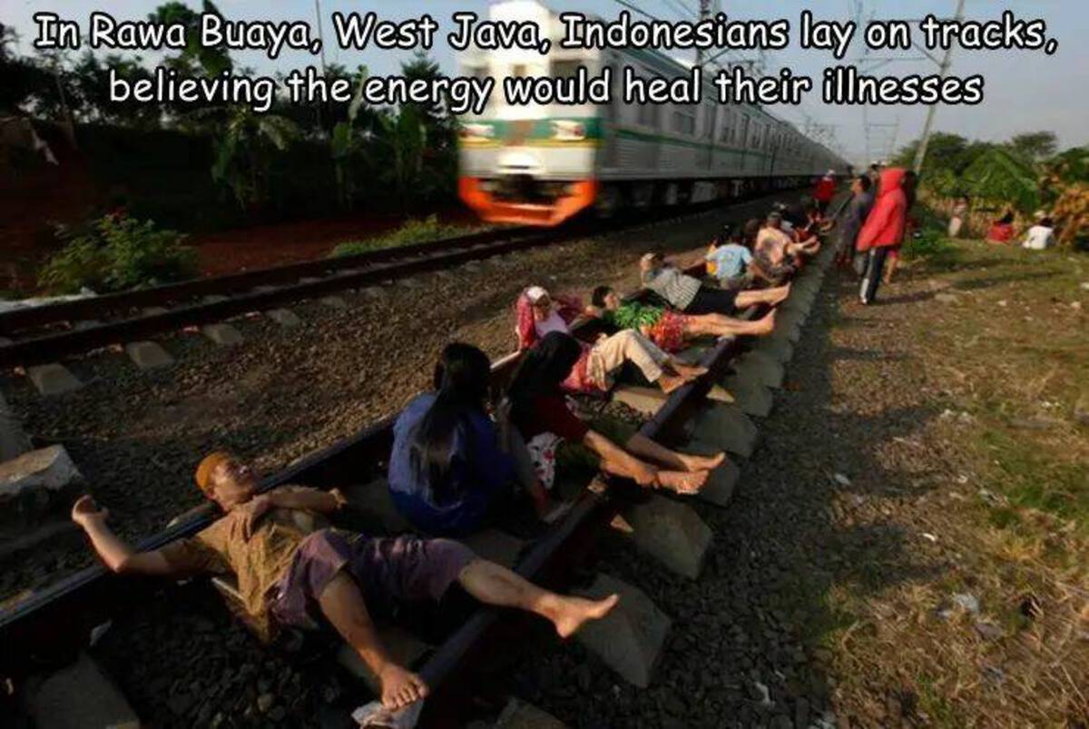 people on train tracks - In Rawa Buaya, West Java, Indonesians lay on tracks, believing the energy would heal their illnesses