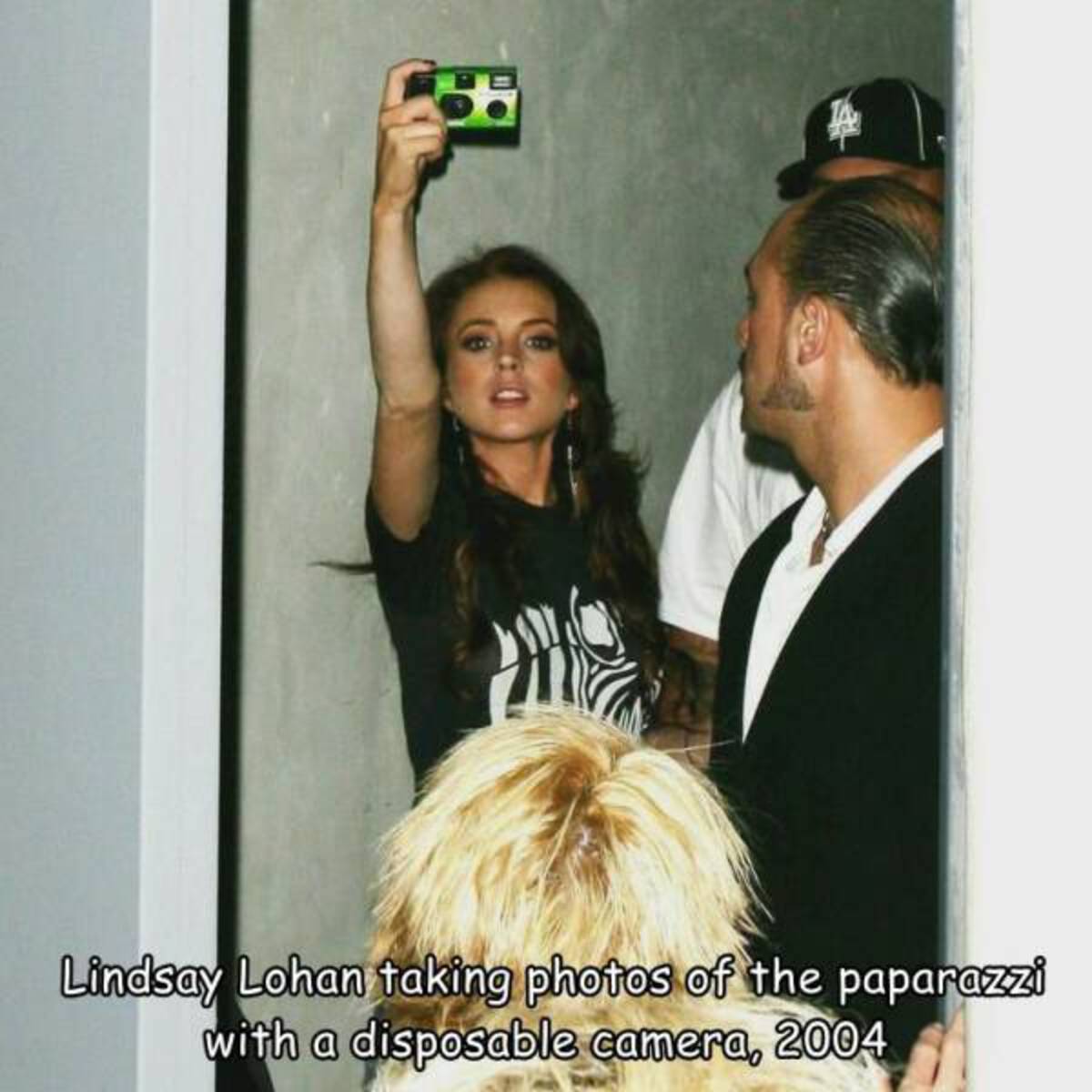 girl - Lindsay Lohan taking photos of the paparazzi with a disposable camera, 2004