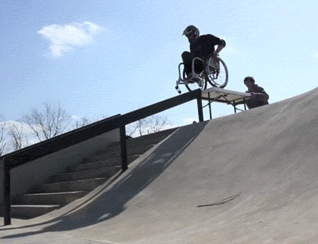 gifs - man slides down a Bannister on a wheelchair and falls