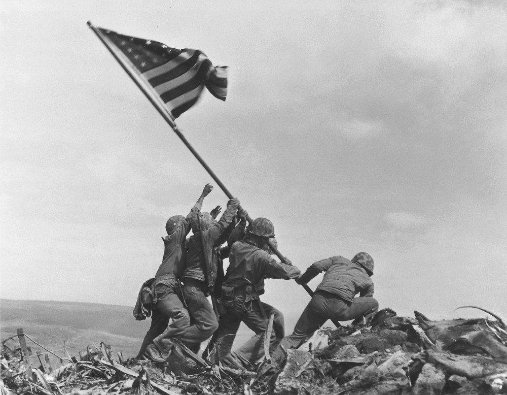 U.S. Marines of the 28th Regiment, 5th Division, raise the American flag atop Mt. Suribachi, Iwo Jima, on February 23, 1945
