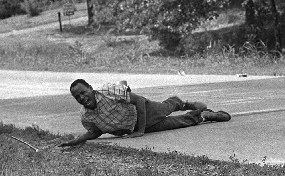 Civil rights activist James Meredith grimaces in pain as he pulls himself across Highway 51 after being shot in Hernando, Miss.,June 6,1966