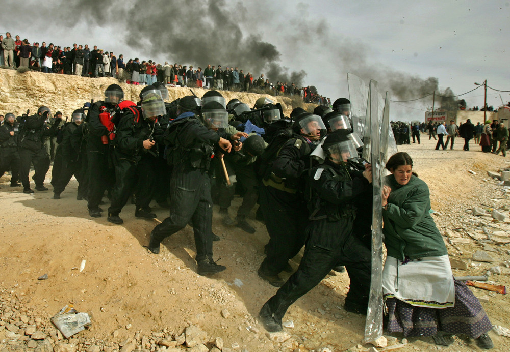 Jewish settler struggles with an Israeli security officer during clashes that erupted as authorities evacuated the West Bank, February 1, 2006