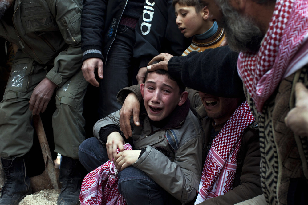 A boy named Ahmed mourns his father, Abdulaziz Abu Ahmed Khrer, who was killed by a Syrian army sniper, during his funeral in Idlib,Syria, March,2012