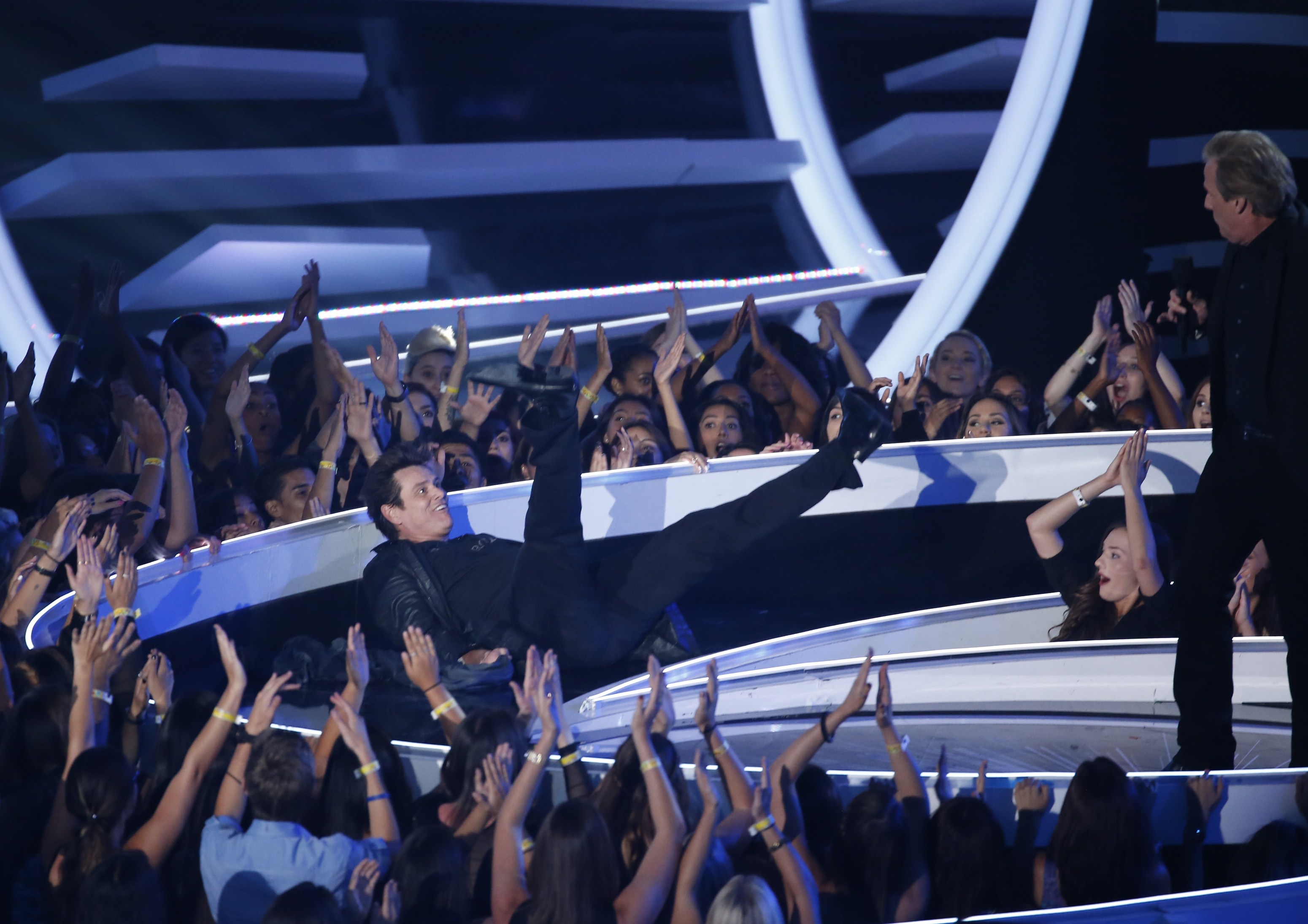 Jim Carey falls backward as he and Jeff Daniels present the award for best pop video during the 2014 MTV Video Music Awards