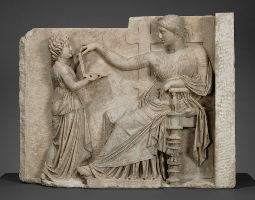 Ancient Greek Laptop? A statue of a woman, dated to about 100 B.C., shows her looking at a modern laptop? The statue is called "Grave Naiskos of an Enthroned Woman with an Attendant."
