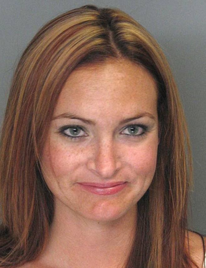 This woman appears to have found the funny side of being arrested as she stifles a giggle during her mugshot