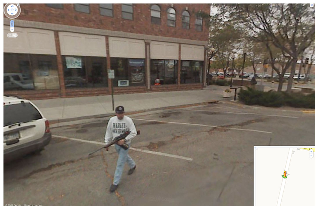 The Google Maps car picks up someone toting a rifle outside of a store.