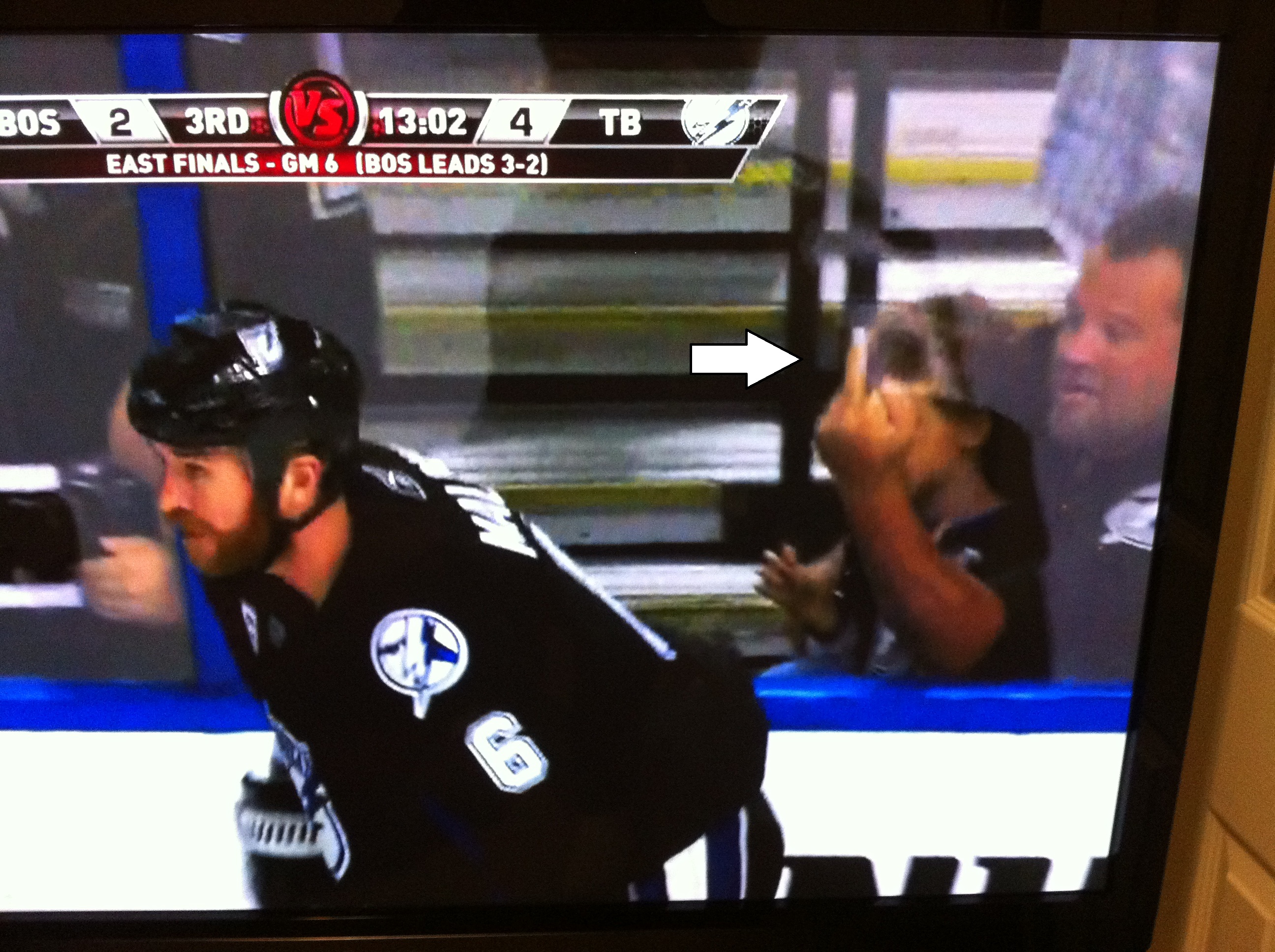A hockey fan holds his kid in one arm while using the other to throw up a bird at a Boston Bruins player on national television during the Eastern Conference finals. Father of the year?