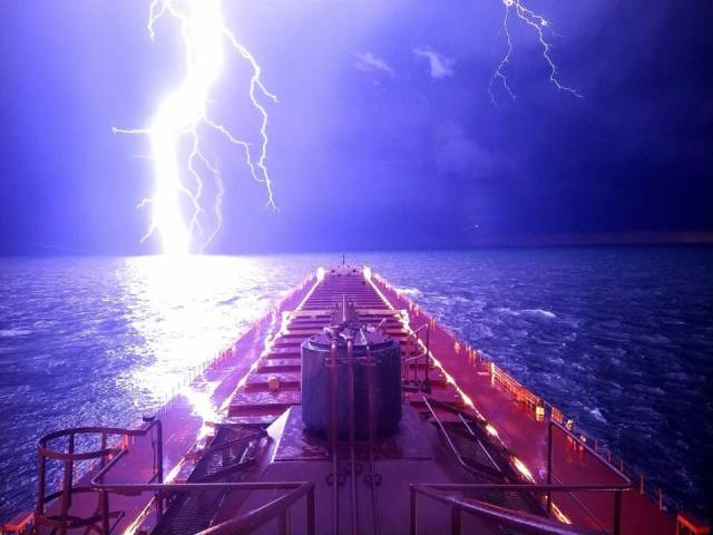 random photo of lightening strike off the edge of a ship in the ocean
