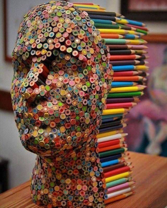 random photo of a face sculptured into glued color pencils